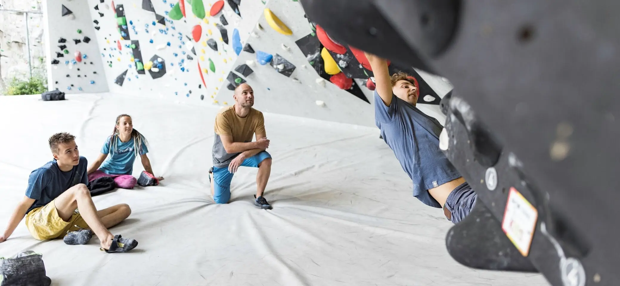 Ein Mann beim Bouldern, im Hintergrund warten weitere Personen, bis sie an der Reihe sind | © DAV / Jens Klatt