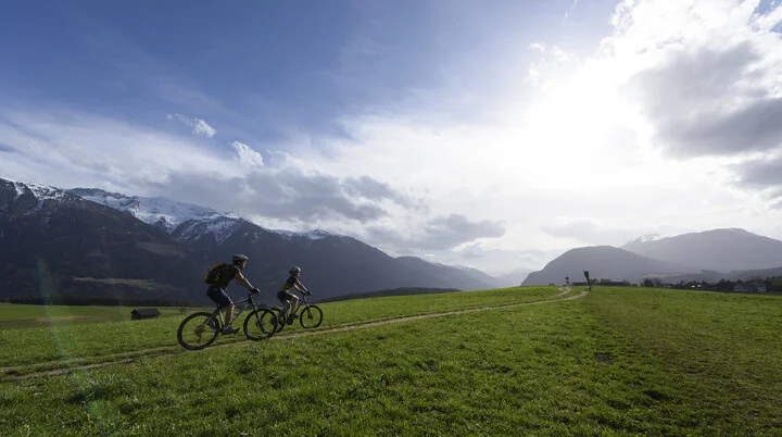Zwei Mountainbikefahrer*innen fahren auf die Berge zu. | © DAV/Wolfgang Ehn